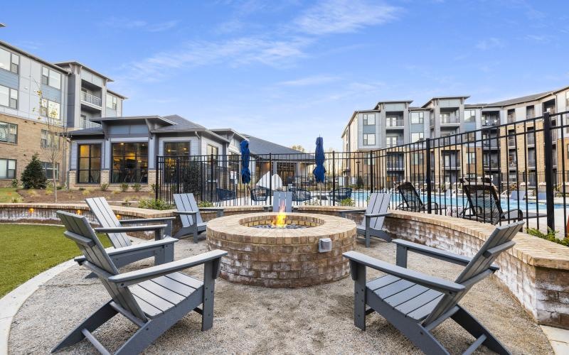 a patio with benches and a fire pit in front of a building